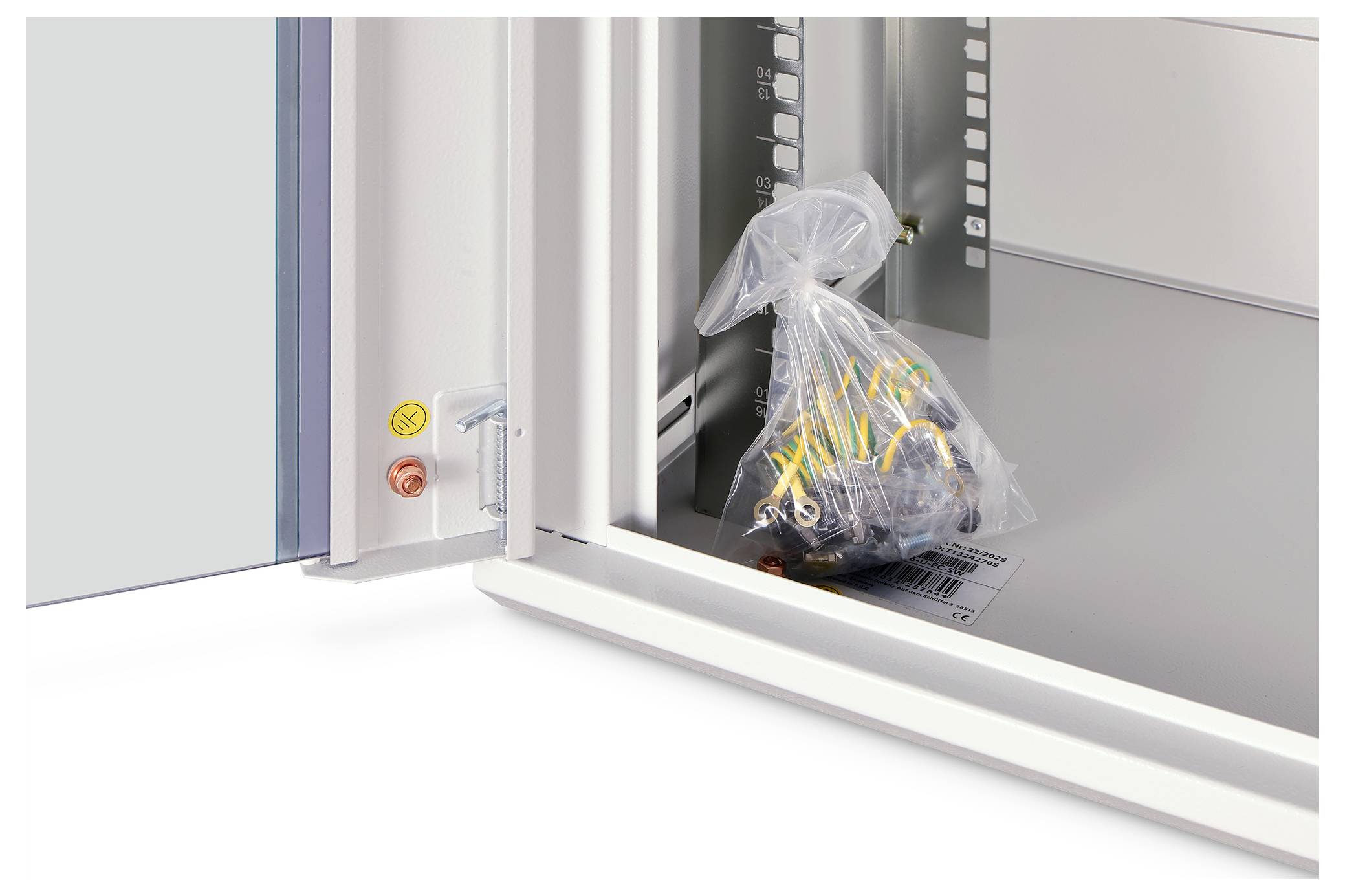 Offener Elektroschalter mit einer Tasche voller Kabel im Inneren, daneben gelbe und rote Druckknöpfe an der Türkante.