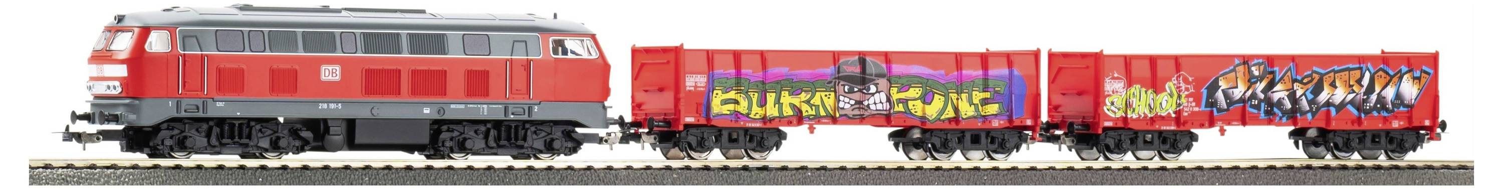 Rot-grauer Güterzug mit Graffiti besprühten Wagen, die auf Schienen fahren.