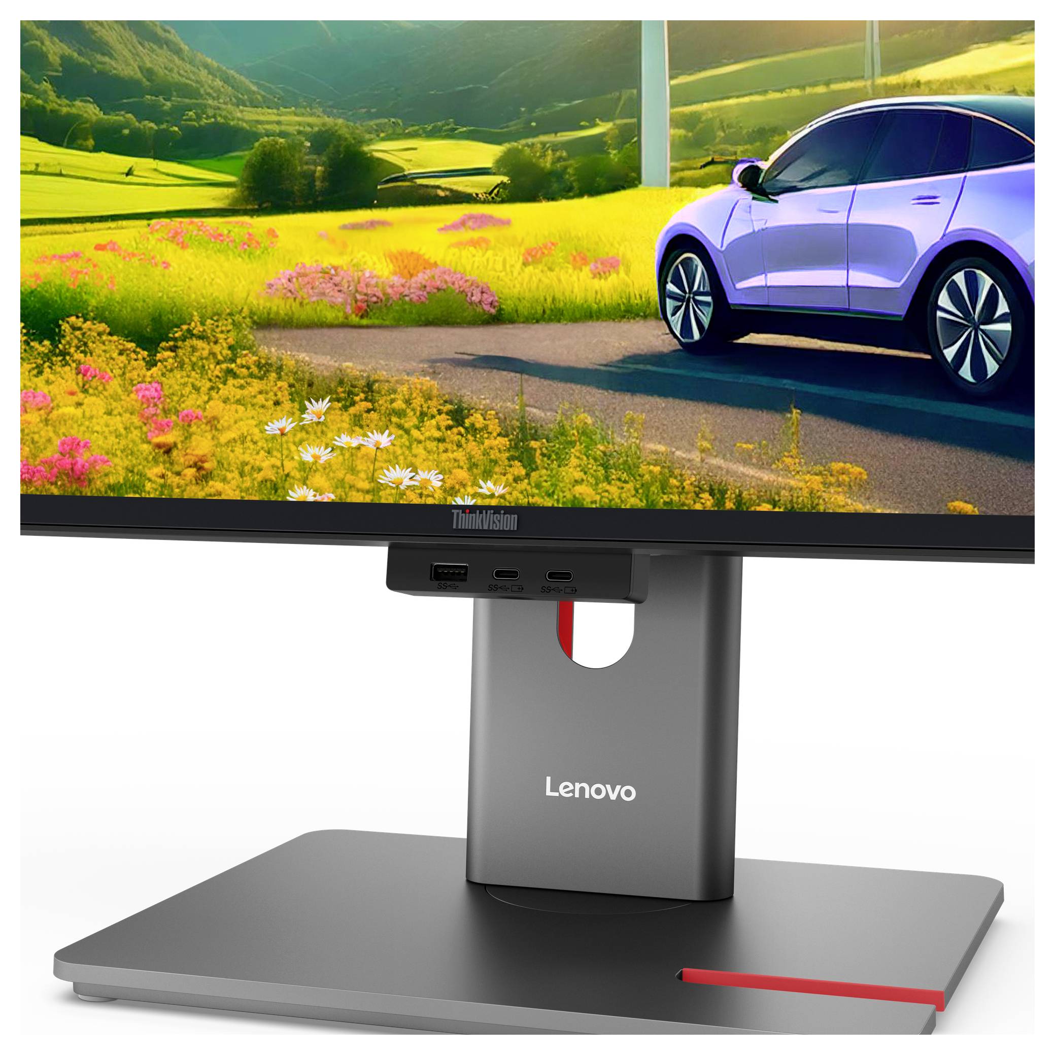 Ein Lenovo-Monitor auf einem Ständer zeigt eine helle Landschaft mit einem weißen Auto, das über eine blütenbesetzte Landstraße fährt.