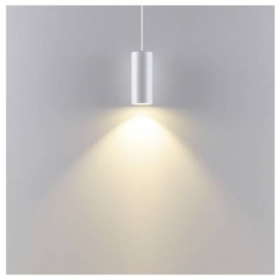 Minimalistische Silberhängeleuchte, die einen warmen Lichtkegel auf eine schlichte graue Wand wirft.