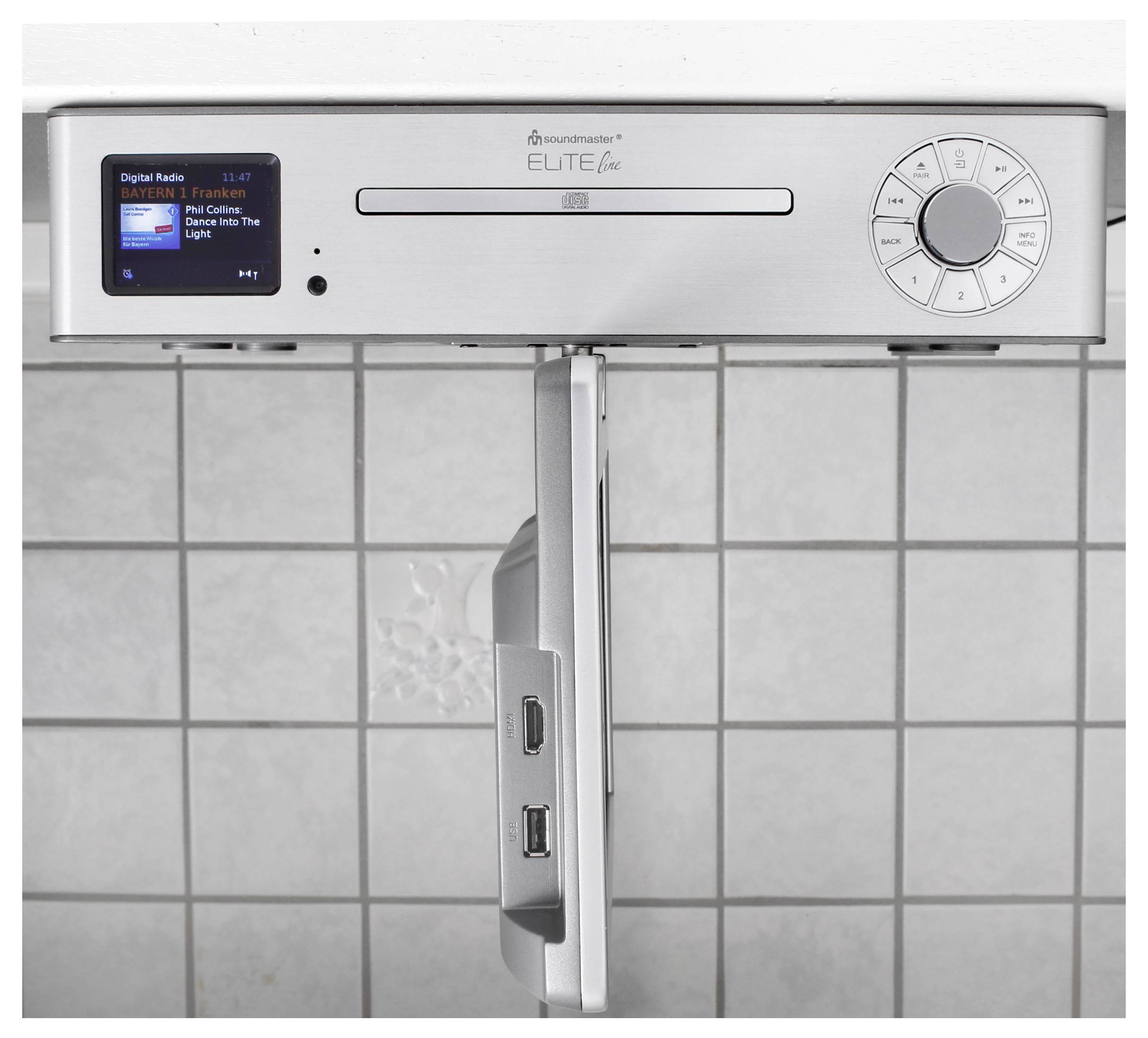 Silber Soundmaster Elite Line Digitalradio mit Display, CD-Schacht und runden Steuertasten an einer gefliesten Wand montiert.