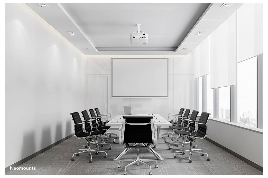 Modernes leeres Konferenzimmer mit einem langen Tisch, schwarzen Drehstühlen, Wandbildschirm, Projektor und großen Fenstern.