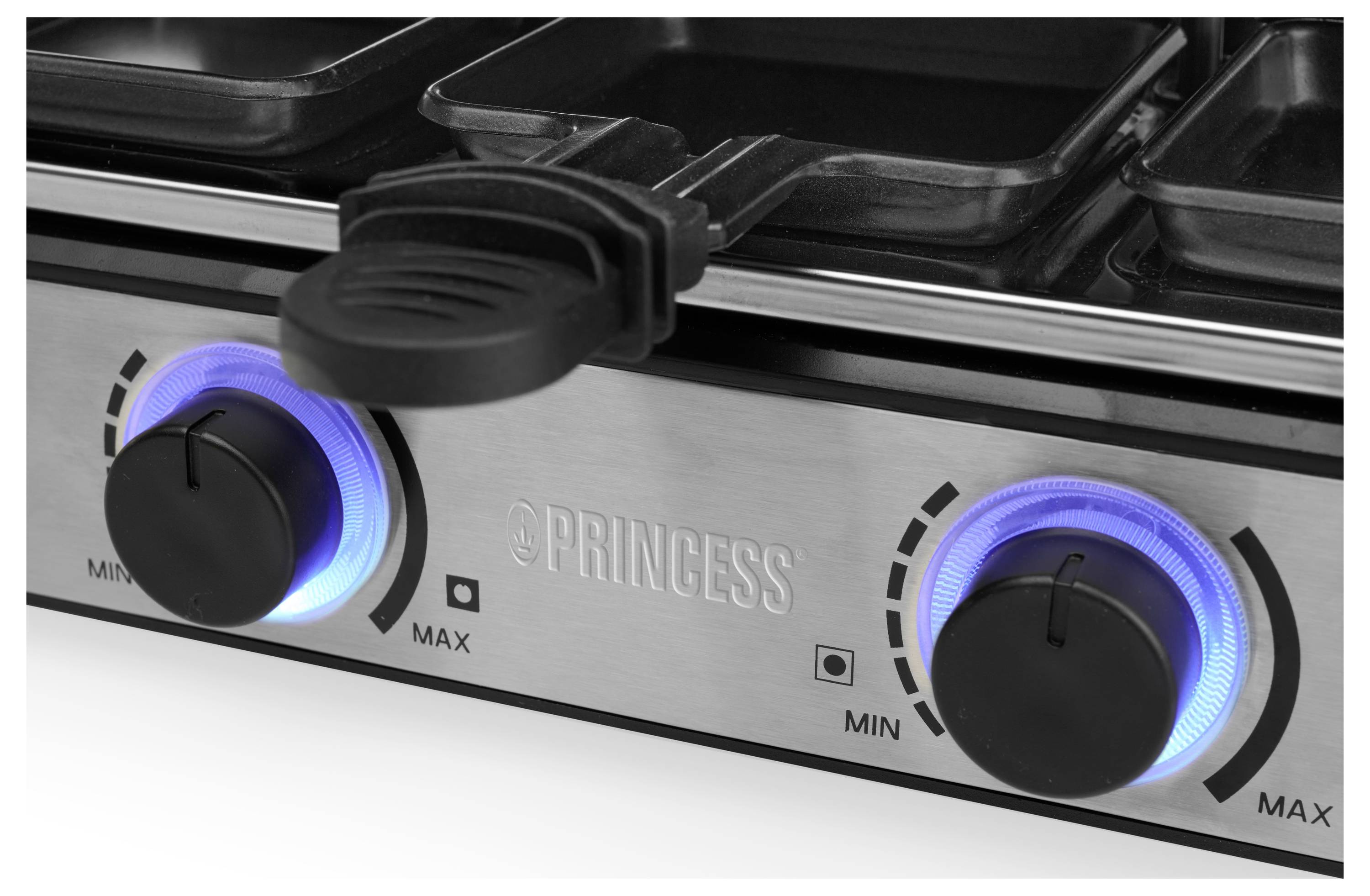 Nahaufnahme einer Edelstahl-Bedienblende eines Princess-Herdes mit zwei schwarzen Knöpfen, die von blauen Indikatorringen beleuchtet werden, mit Markierungen für minimale und maximale Hitze.