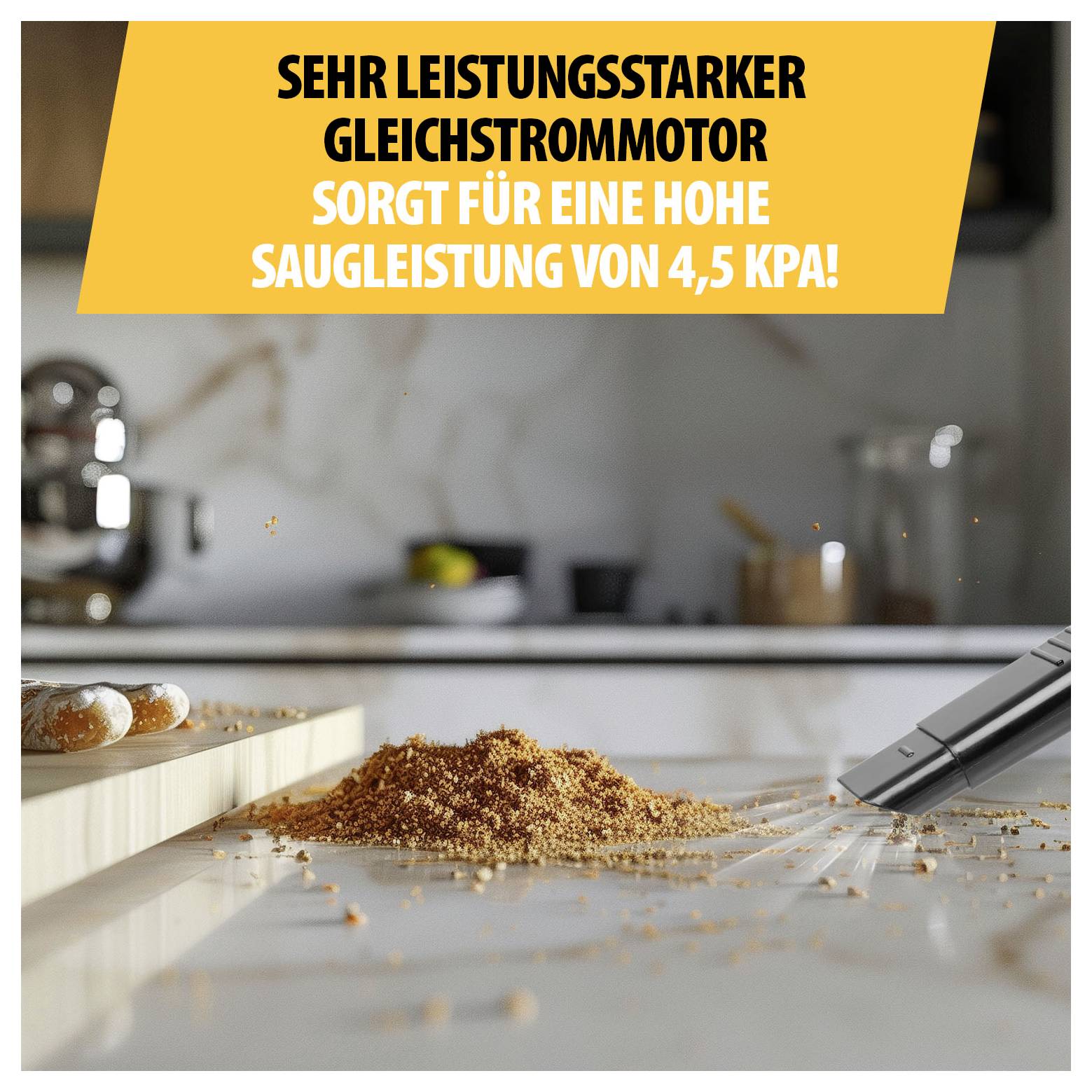 Werbebild eines Staubsaugers mit Text 'SEHR LEISTUNGSSTARKER GLEICHSTROMMOTOR SORGT FÜR EINE HOHE SAUGLEISTUNG VON 4,5 KPA!' beim Aufsaugen von Krümeln in einer Küche.