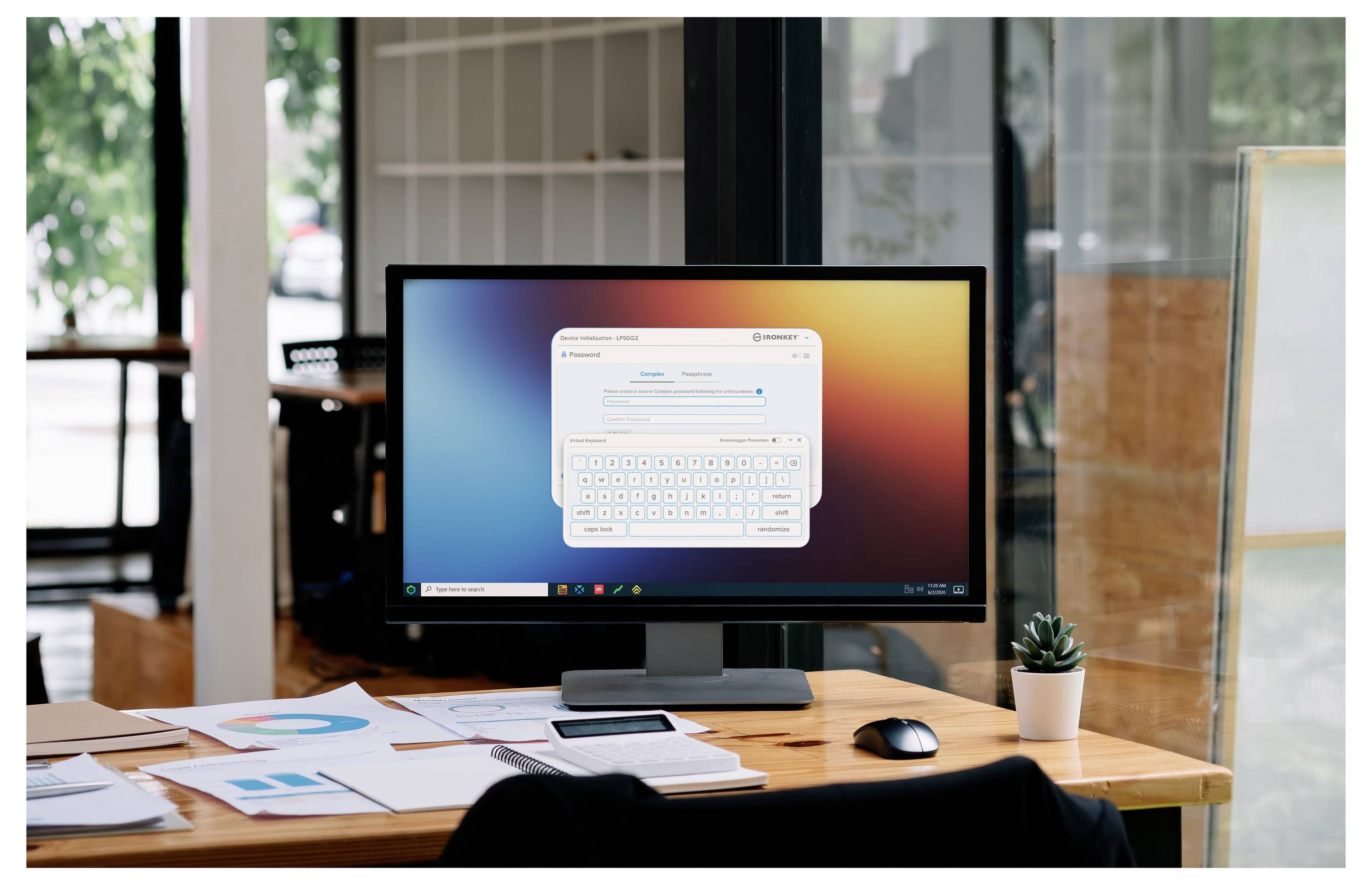 Desktop-Monitor auf einem Holzschreibtisch zeigt ein Softwarefenster mit einer virtuellen Tastatur auf dem Bildschirm, umgeben von Papieren, einem Telefon, einer Maus und einer kleinen Pflanze in einer büroähnlichen Umgebung