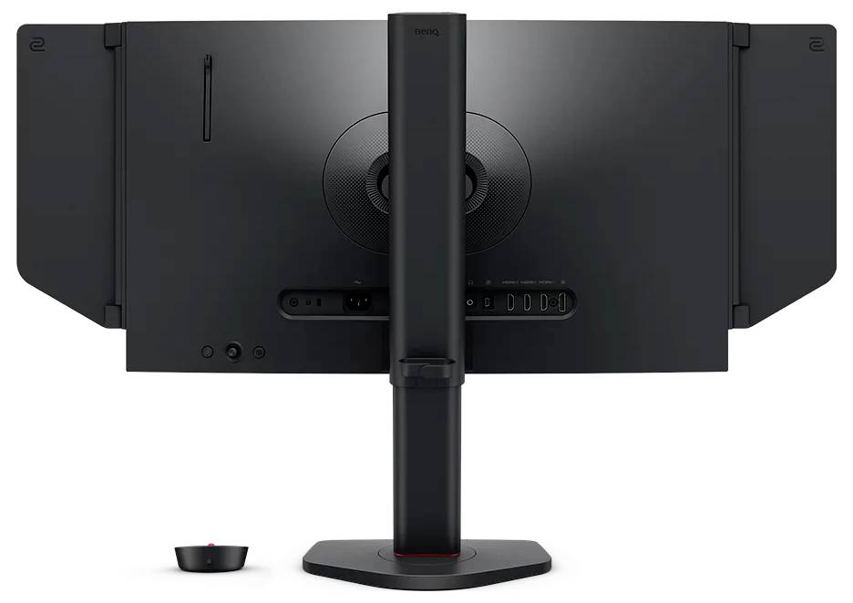 Rückansicht eines schwarzen Computermonitors auf einem Ständer, die das Rückenelement, die Kabelanschlüsse und ein kleines Zubehörteil, das darunter platziert ist, zeigt.
