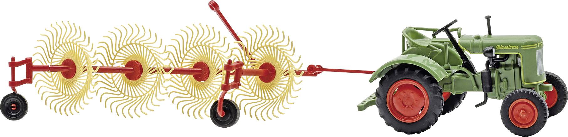 Ein grüner Traktor zieht eine rote Rotationsfräse, wobei sich dahinter drehende Zinken zeigen, die Erde aufschneiden und lockern.