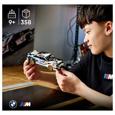 Ein Junge hält und bewundert ein LEGO BMW M Rennwagen-Modell; das Bild zeigt eine Altersfreigabe ab 9 Jahren und 358 Teile.