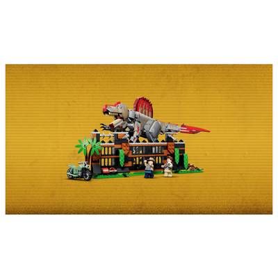 Eine LEGO-artige Szene mit einer Dinosaurier-Ausstellung mit einem großen rot-grauen Dinosaurier auf einem Gebäude, Palmen und zwei Minifiguren davor.
