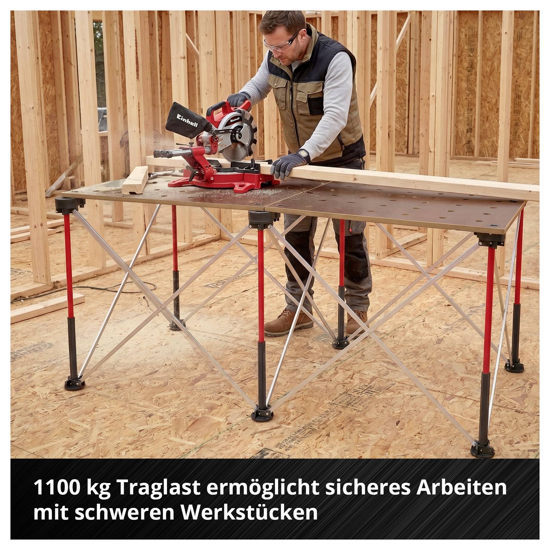 Ein Handwerker sägt mit einer Kappsäge auf einem stabilen Arbeitstisch; Hinweistext: '1100 kg Traglast ermöglicht sicheres Arbeiten mit schweren Werkstücken'.<br>