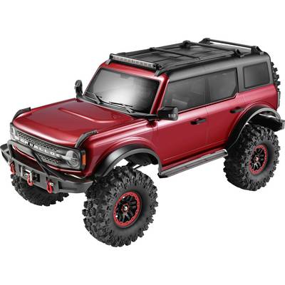 Roter Geländewagen mit übergroßen Profilreifen, schwarzem Dach und schwarzer Blende, in einer Dreiviertel-Frontansicht auf weißem Hintergrund dargestellt.
