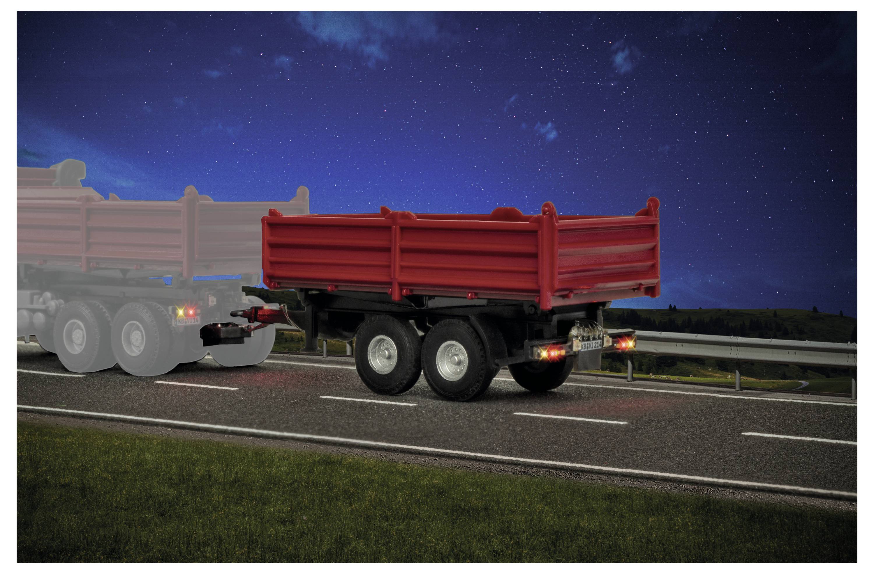 Roter Anhänger-Lastkraftwagen auf einer nächtlichen Autobahn, von hinten gezeigt mit einem anderen Lastkraftwagen, der teilweise neben ihm sichtbar ist.