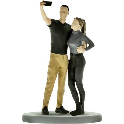 Ein Mann- und Frauenfigurchen posieren für ein Selfie, stehen zusammen auf einer runden Basis.