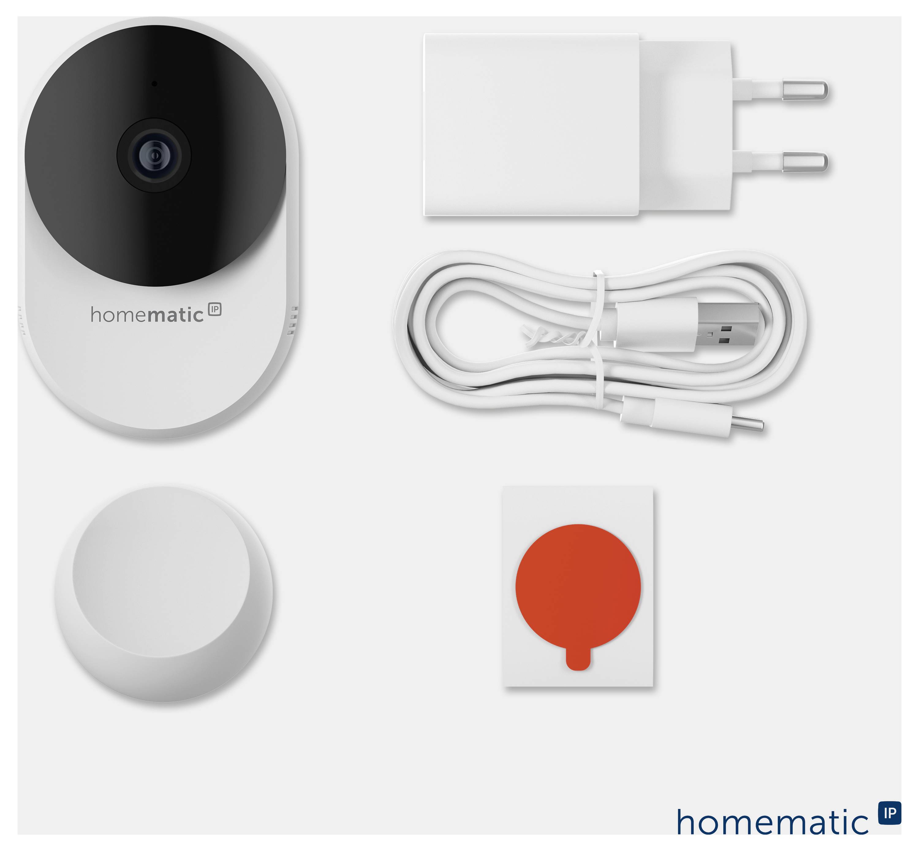 Homematic IP Starterset mit Wandsensor, Netzteil, USB-Kabel, runder Basisstation und rotem Schaltflächen-Zubehör auf weißem Hintergrund.