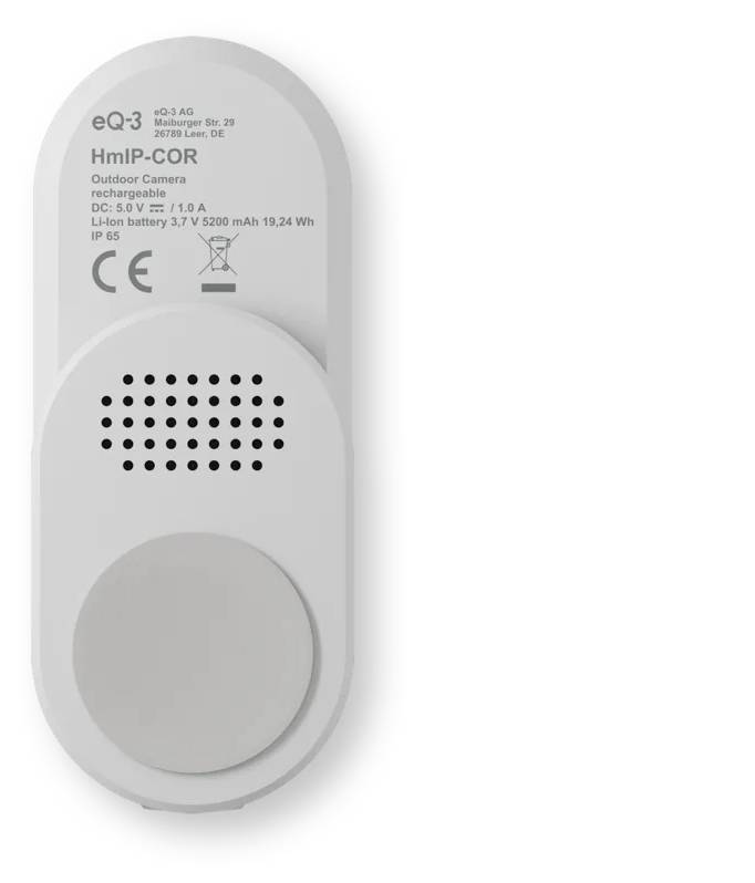 Weiße Outdoor-Kamera mit Akkuladung an einer Wand angebracht, von hinten gezeigt mit Lautsprechergitter, großem kreisförmigem Sockel und gedruckten Modell- und Strombezeichnungen.