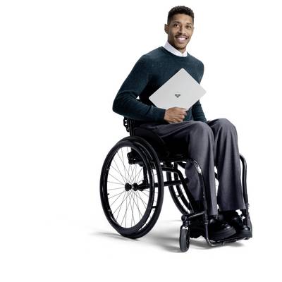 Mann im Rollstuhl, der lächelt und einen Laptop gegen einen weißen Hintergrund hält.
