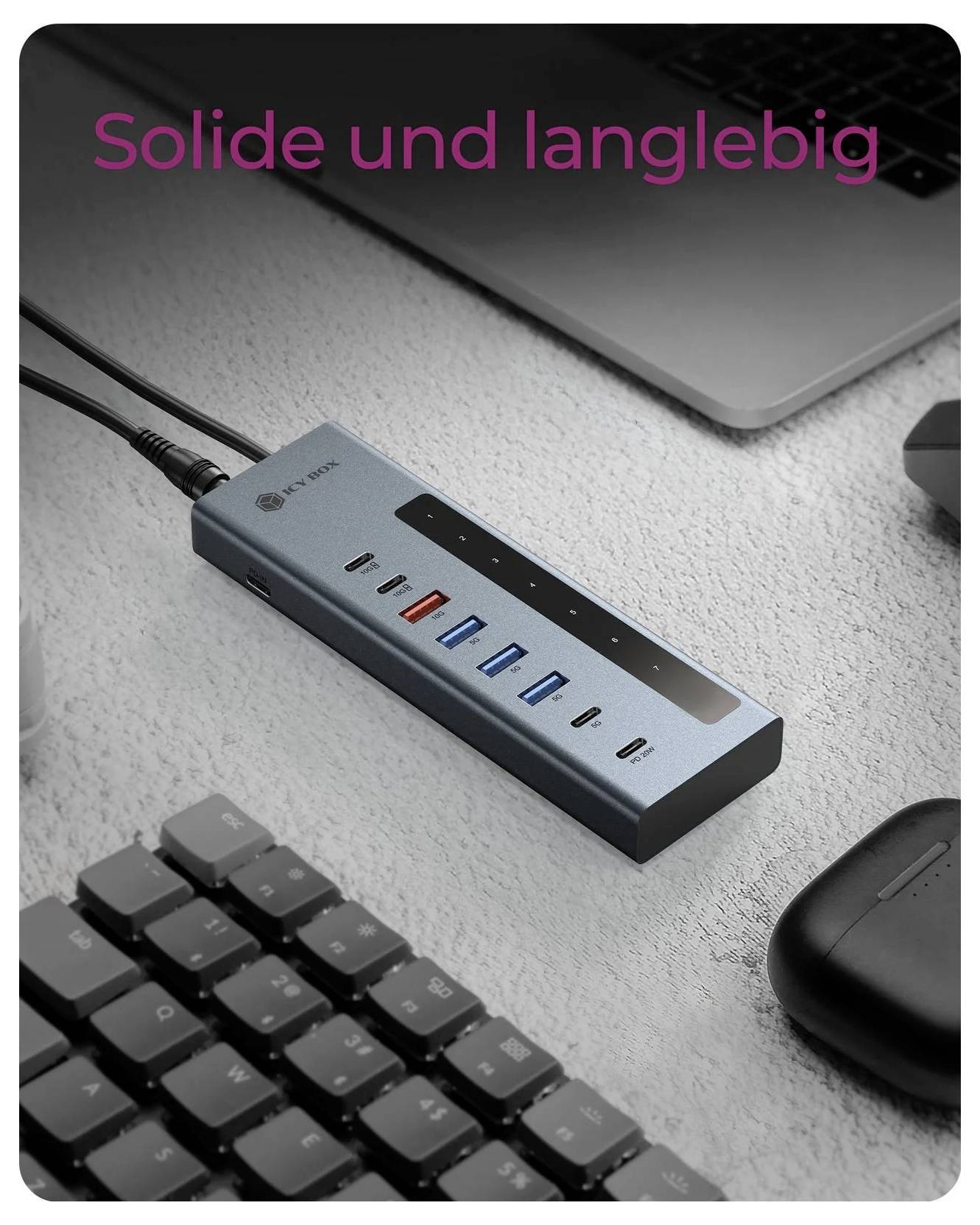 USB-C Dockingstation auf einem Schreibtisch neben einem Laptop, einer Tastatur und einer Maus, mit dem deutschen Text „Solide und langlebig", was auf Deutsch „robust und langlebig" bedeutet.