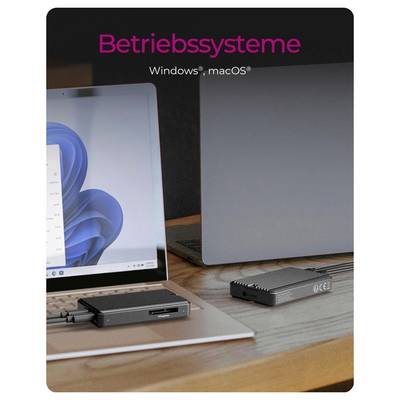 Ein Laptop und ein Monitor im Desktop-Stil stehen auf einem Schreibtisch mit kleinen externen Geräten davor; der Text lautet „Betriebssysteme" und „Windows, macOS".