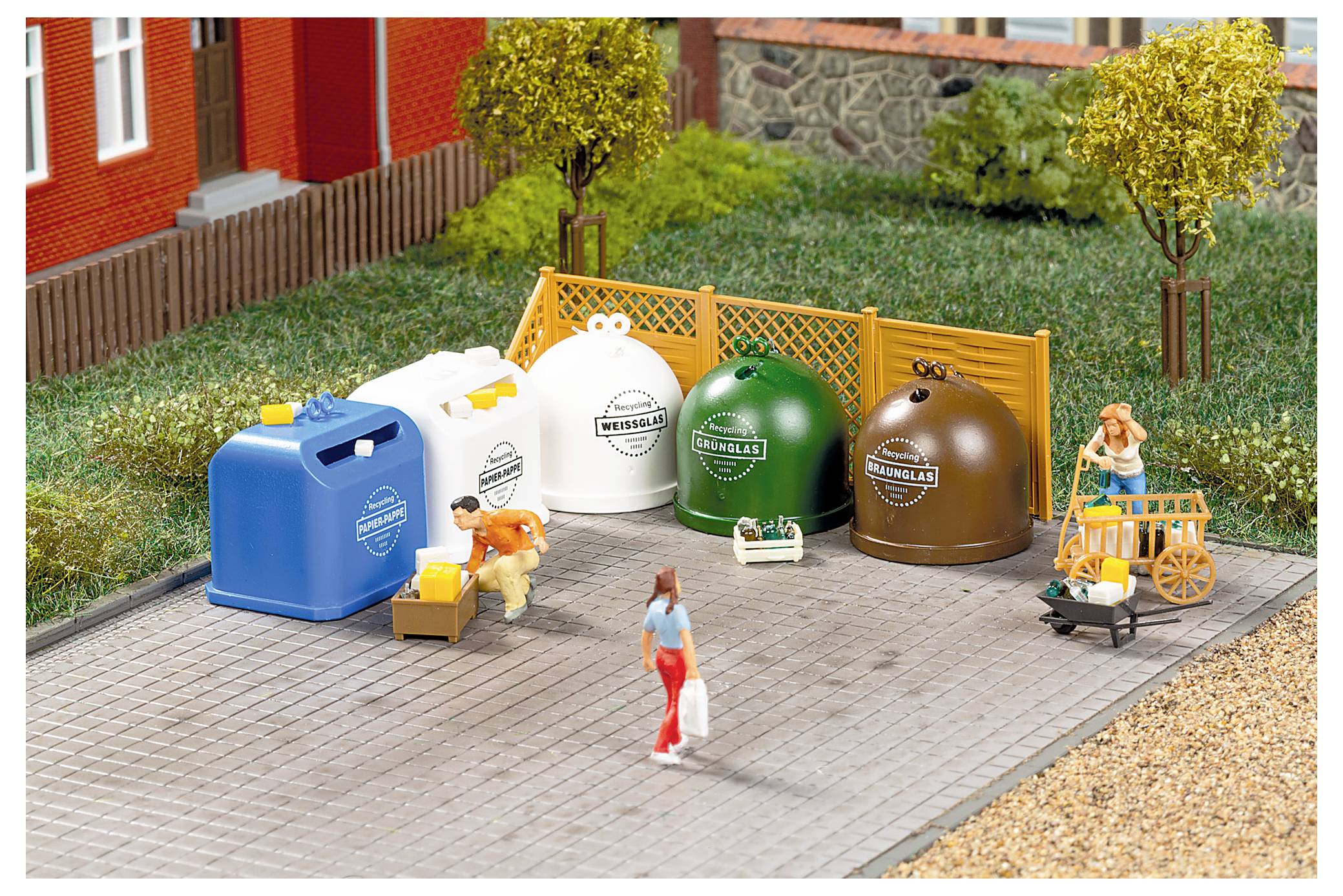 Miniatur-Recycling-Szenerie mit beschrifteten Behältern für blaues Papier, weiße, grüne und braune Abfallstoffe, ein Arbeiter, der Kartons lädt, und ein Fußgänger, der vorbeigeht.