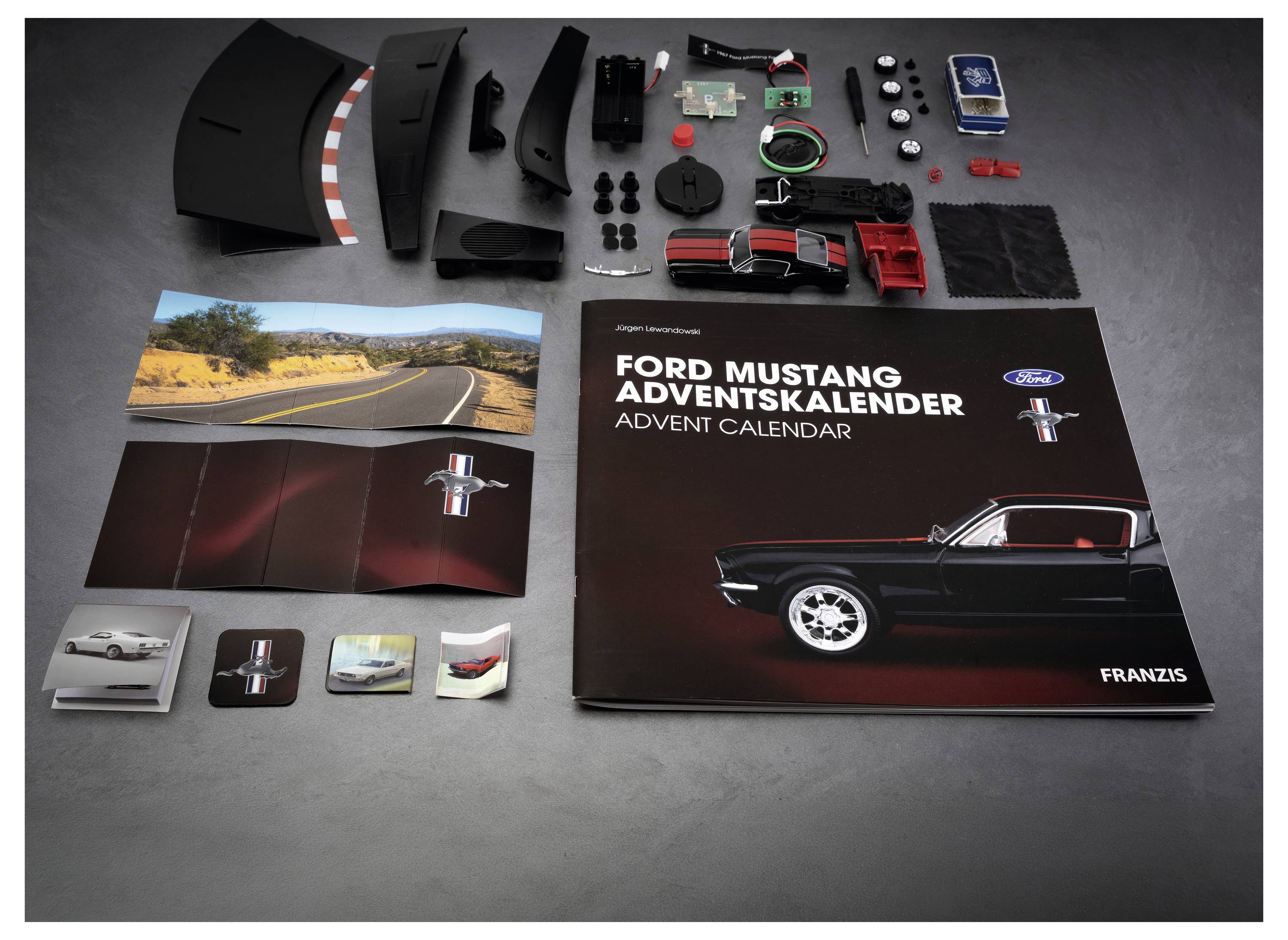 Ford Mustang Adventskalender-Inhalte auf einem Tisch ausgebreitet, einschließlich der Kalenderbox, Autobilkarten und kleiner Modellteile und Zubehör.