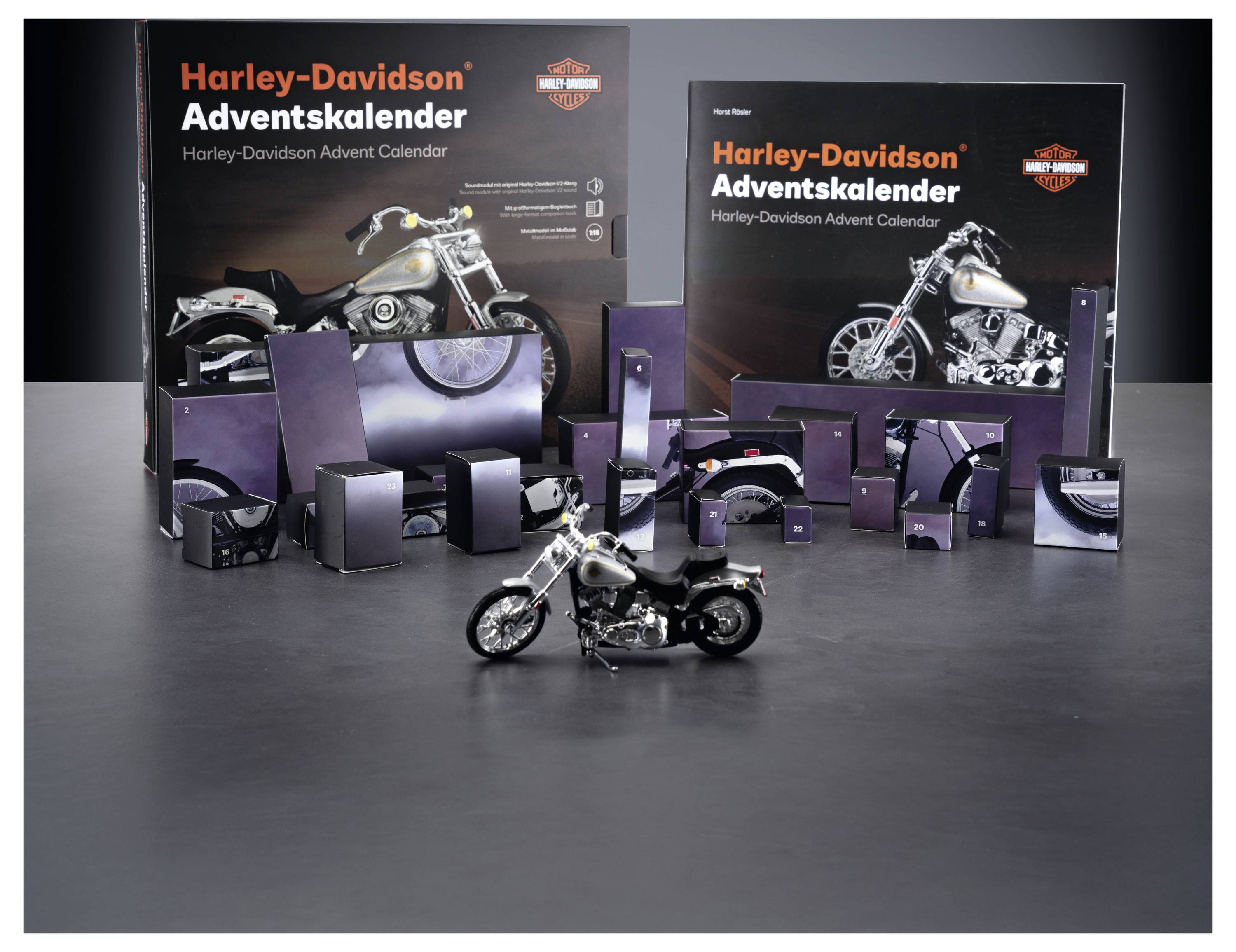 Harley-Davidson Adventskalender-Display mit zwei großen Produktboxen und einem Miniatur-Motorrad davor, das verschiedene verpackte Teile oder Geschenke zeigt