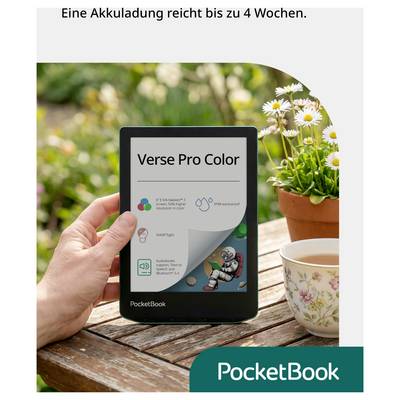 Eine Hand hält einen PocketBook Verse Pro Color e-reader auf einem Holztisch neben Blumen und einer Teetasse; der Text lautet „Eine Akkuladung reicht bis zu 4 Wochen" und „PocketBook".