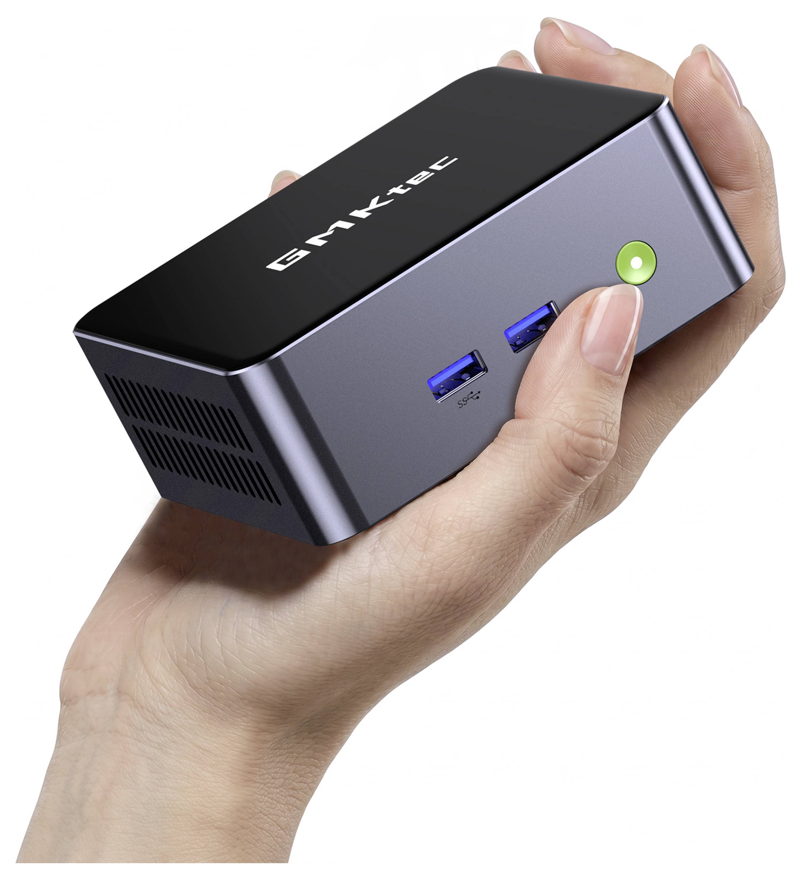 Hand, die einen kleinen schwarz-silbernen GMKtec Mini-PC mit zwei blauen USB-Anschlüssen und einem grünen Netzschalter hält.
