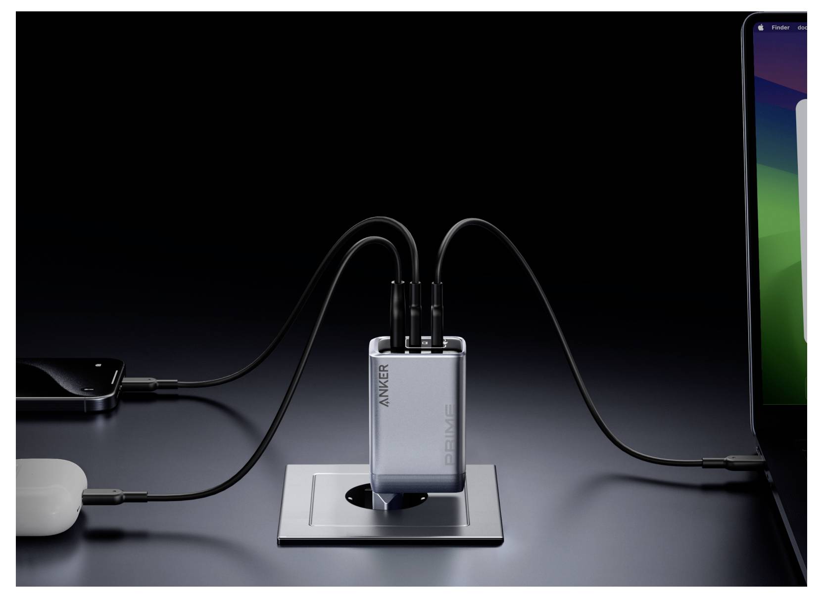 Anker Power Hub auf einem Schreibtisch lädt mehrere Geräte auf, mit Kabeln, die mit einem Telefon, einem Kopfhörerhülle und einem Laptop verbunden sind.