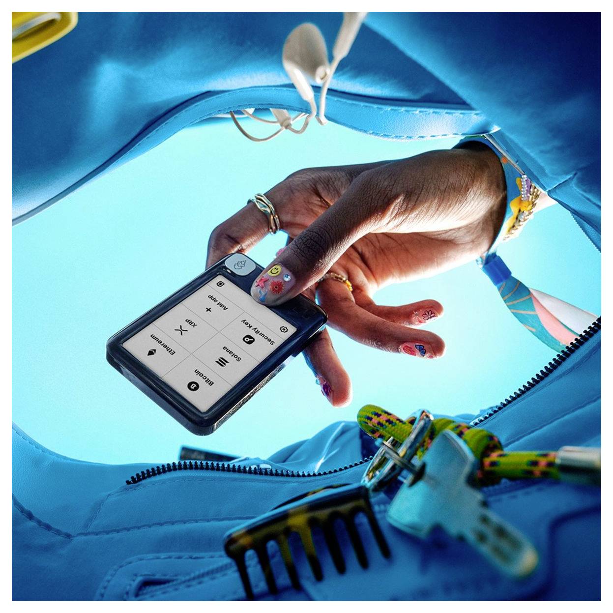 Hand hält ein Smartphone mit Musiksteuerungen in einer blauen Tasche, aus der Ich-Perspektive gesehen, mit Kopfhörern und Ausrüstung in der Nähe.