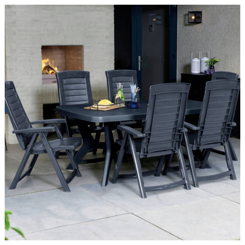Terrassenspeisebereich mit schwarzem Tisch und sechs Stühlen neben einem eingebauten Kamin, an einer Tür und Wand mit einem kleinen Beistelltisch.