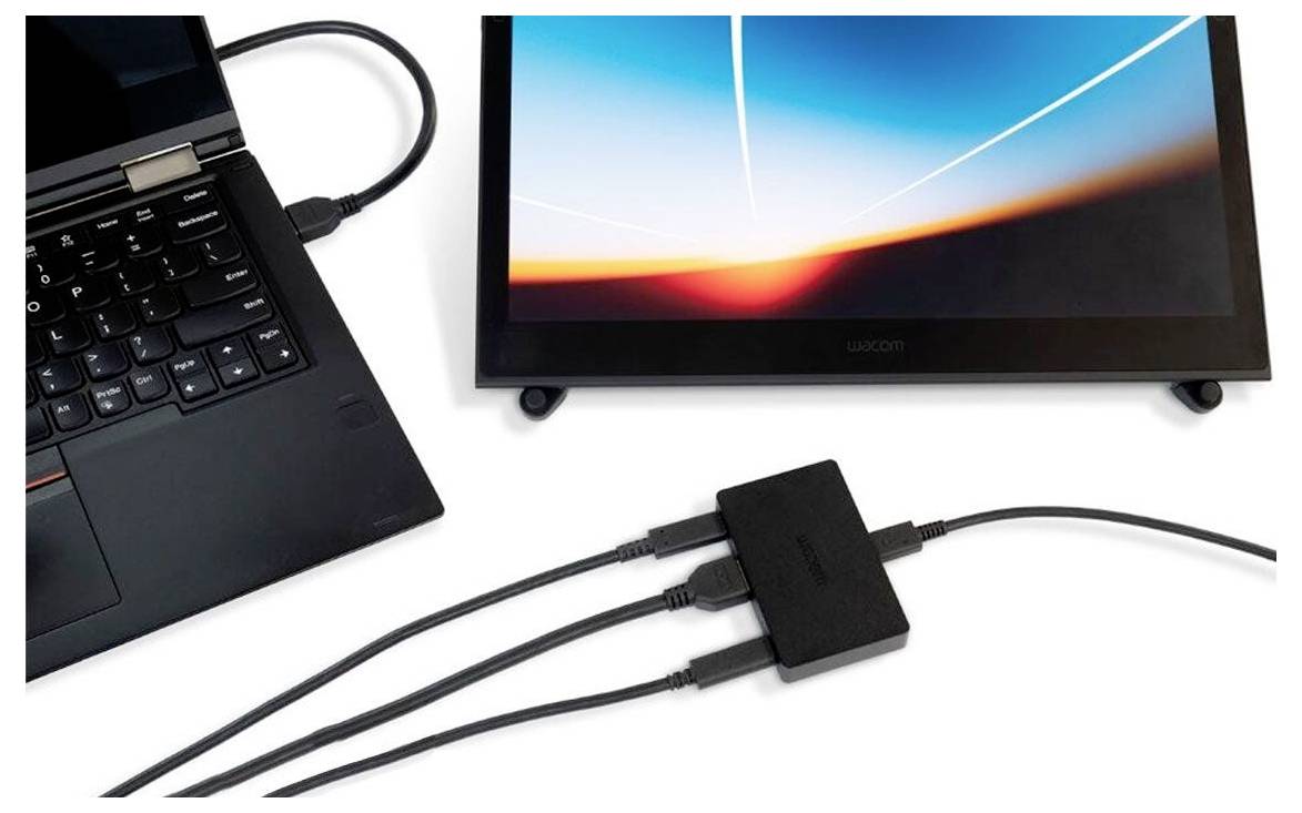 Laptop verbunden mit einem externen Monitor über ein Dock oder einen Adapter mit mehreren Kabeln auf weißem Hintergrund.