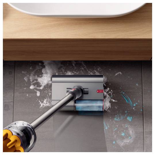 Kabelloses Staubsauger reinigt Verschüttetes auf einem dunklen Fliesenboden unter einem Holzschrank.
