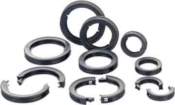 Assortierte schwarze und silberne geteilte Sicherungsringe und Ringclips auf weißem Hintergrund.