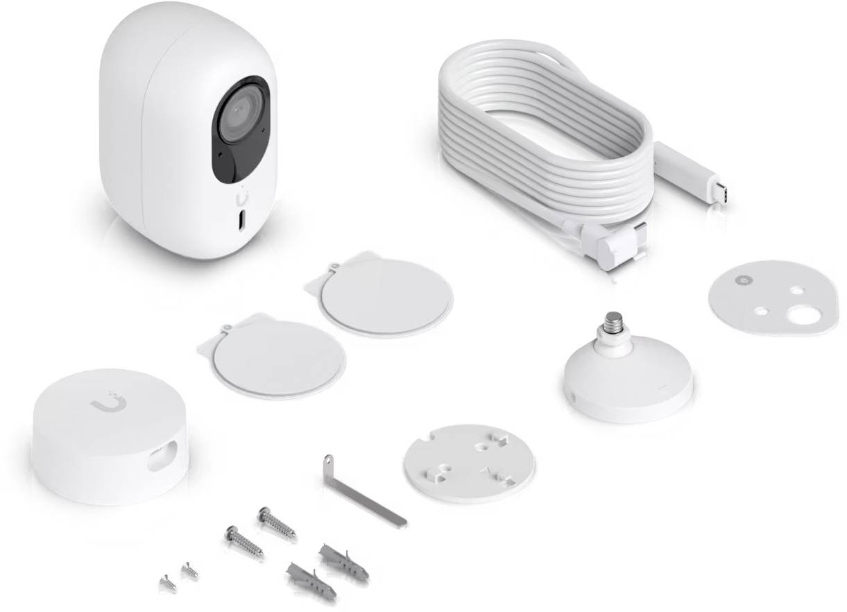 Ein weißes Smart-Home-Kamera-Set mit einer Kameraeinheit, USB-Kabel, magnetischen Halterungen, Wandplatten, Schrauben und Dübeln auf weißem Hintergrund angeordnet.