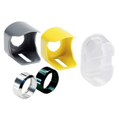 Sortierte dekorative Ring- oder Knopfabdeckungen aus Kunststoff und Metall in Grau, Gelb, Weiß, Silber und Schwarz auf weißem Hintergrund.