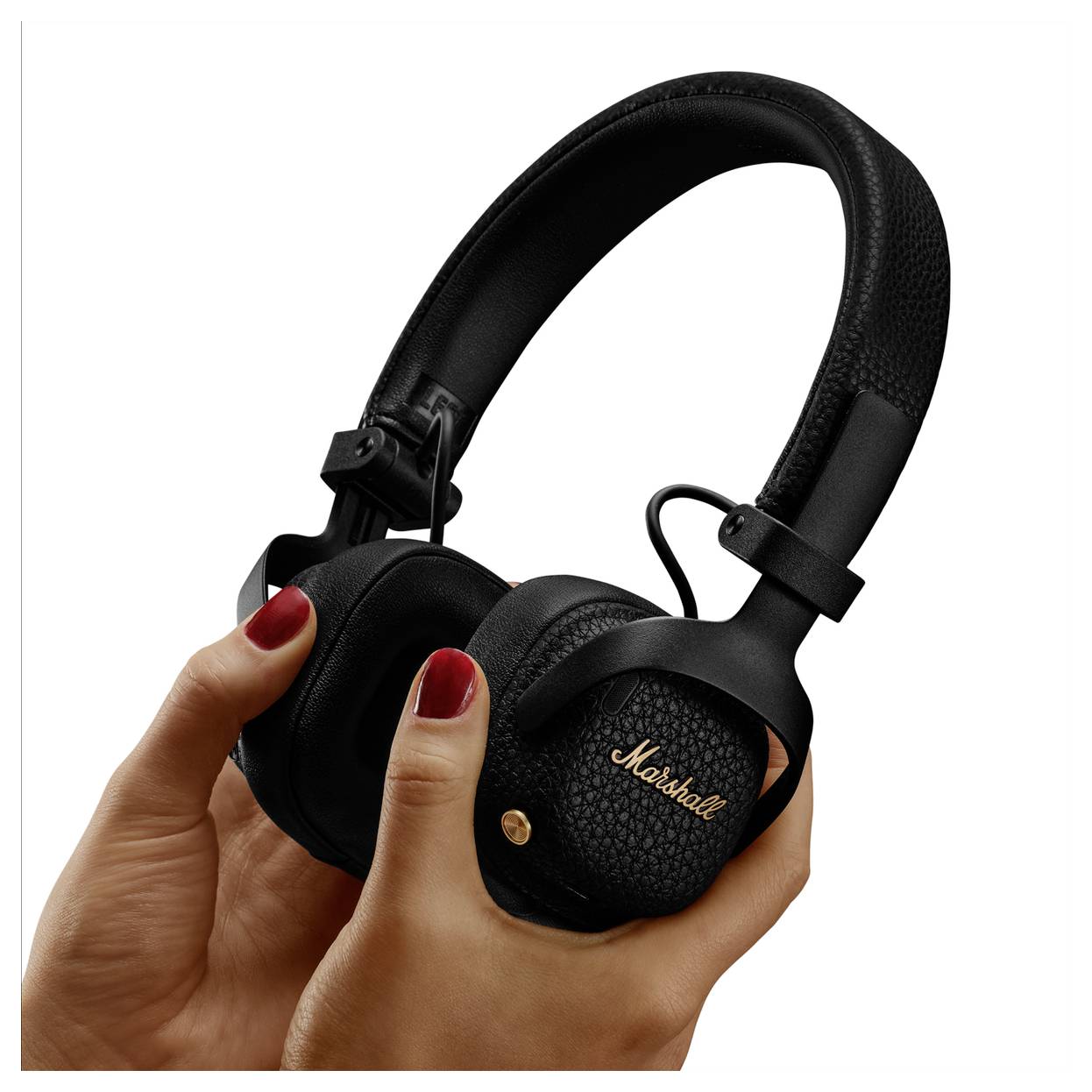 Hände halten schwarze Marshall Over-Ear-Kopfhörer mit goldenem Logo auf der Ohrmuschel vor weißem Hintergrund.