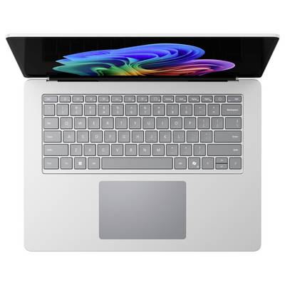 Laptop mit farbenfrohem abstraktem Display und grauer Tastatur, von oben auf weißem Hintergrund betrachtet.