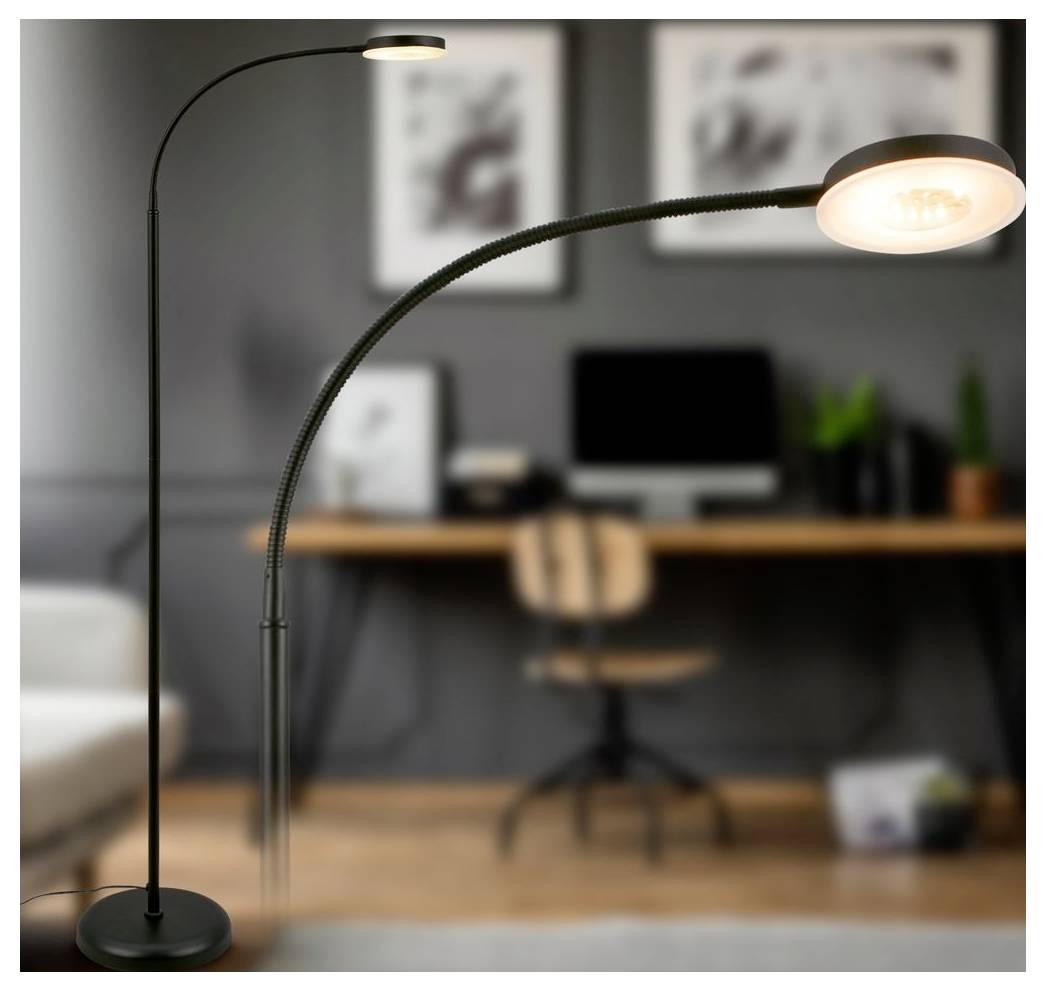 Zwei moderne Stehleuchten mit geschwungenen schwarzen Stangen leuchten in einem unscharfen Homeoffice, eine Vordergrundleuchte leuchtet über einen Schreibtisch und einen Stuhl.
