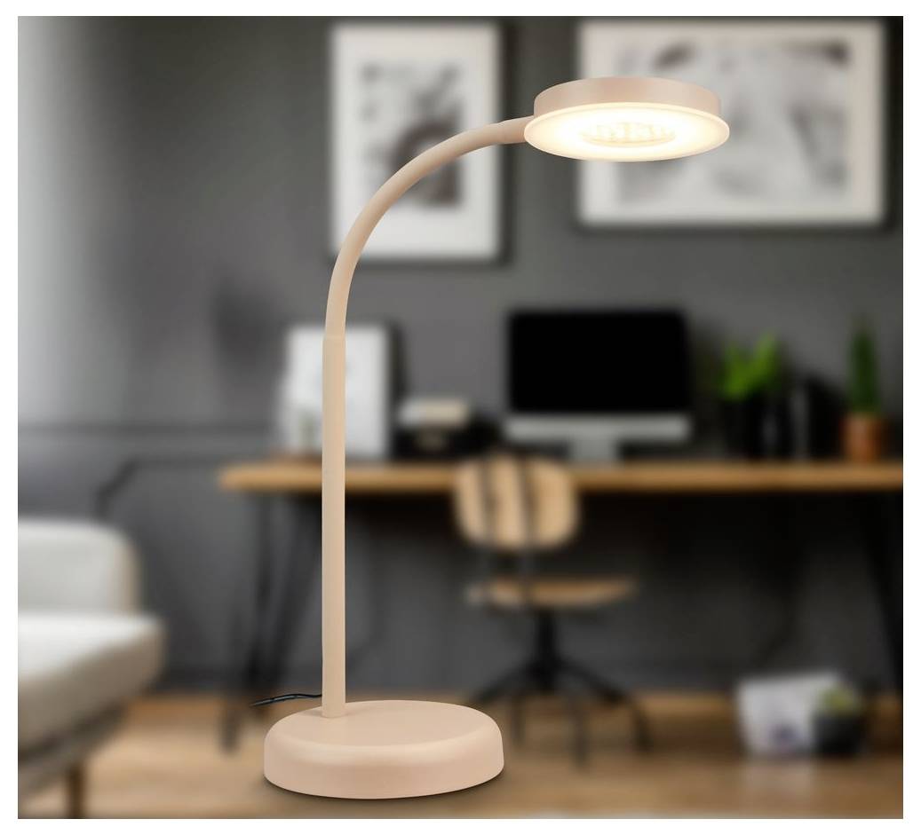 Moderne beige LED-Schreibtischlampe, die auf einer runden Basis in einem Heimbüro leuchtet.