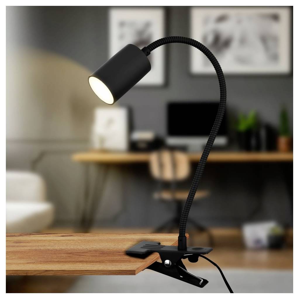Schwarze Klemmleuchte mit Schwanenhals, die einen Holztisch in einem Homeoffice-Setting beleuchtet