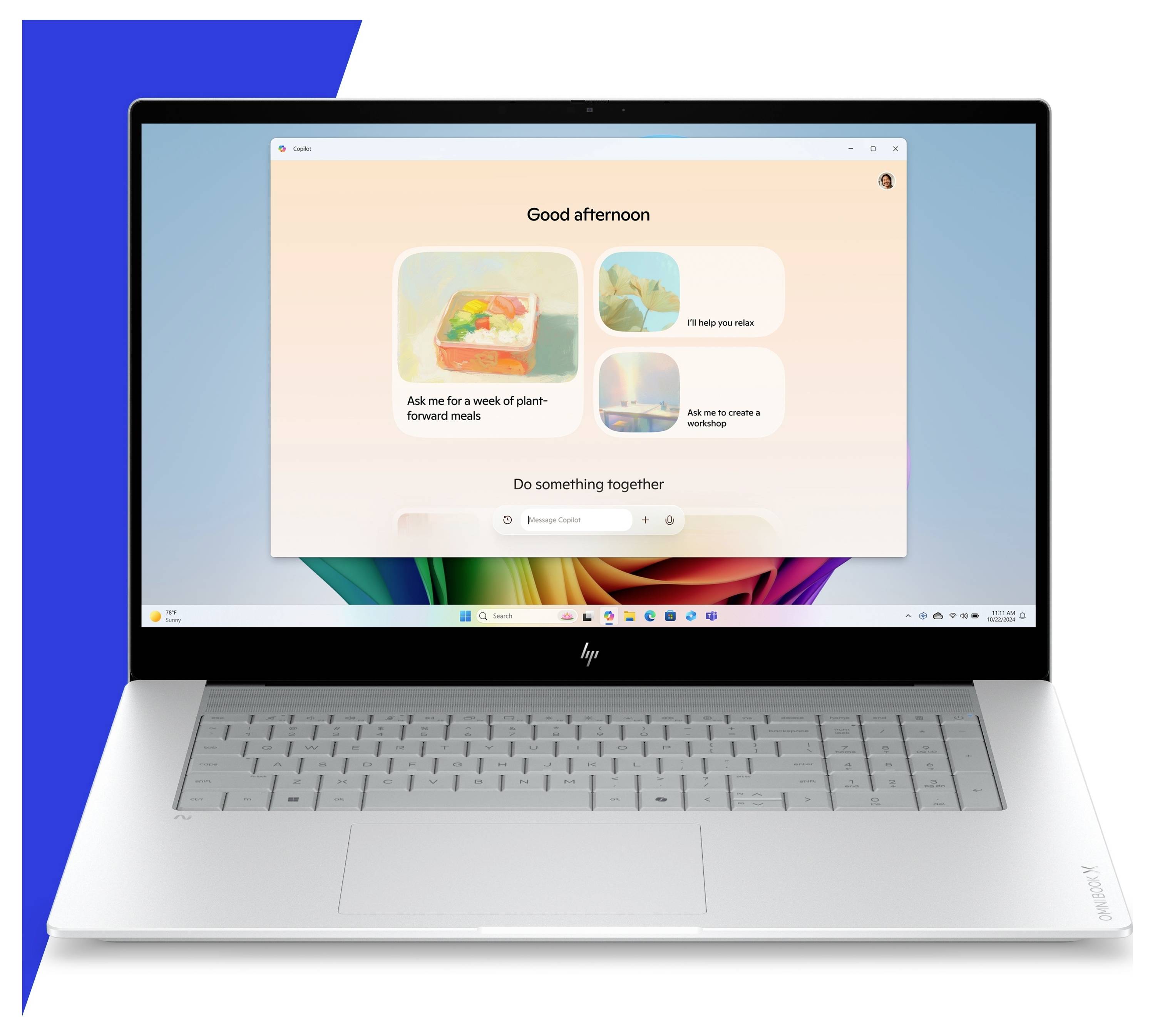 Silberner HP-Laptop auf blauem Hintergrund geöffnet, zeigt einen Windows-Startbildschirm mit einem zentrierten Assistentenfenster und dem Text „Guten Nachmittag".