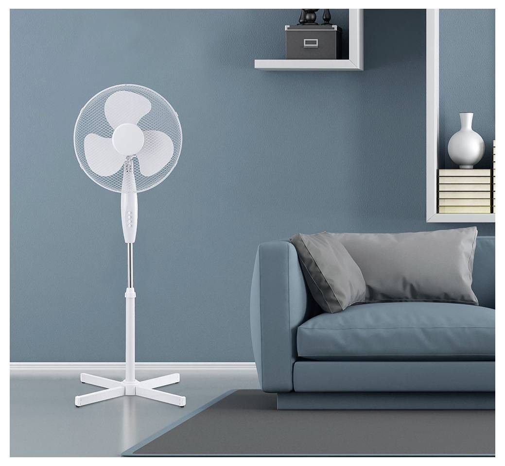 Weißer Standventilator neben einem blauen Sofa in einem minimalistischen Wohnzimmer in Blaugrün mit Wandregalen und einer Vase.