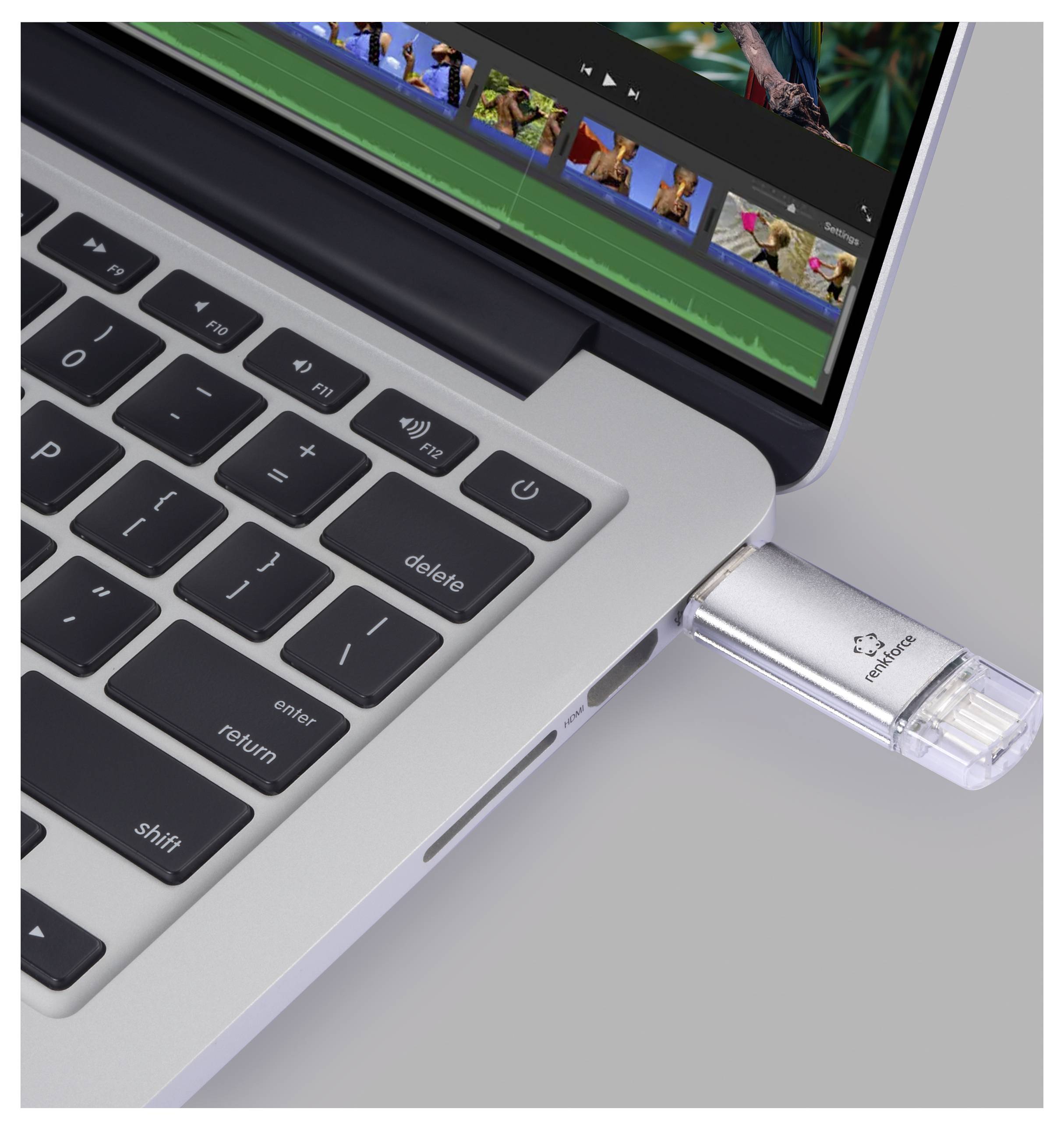 Ein USB-Stick ist in einen USB-Anschluss des Laptops eingesteckt, während auf dem Bildschirm Videobearbeitung sichtbar ist.