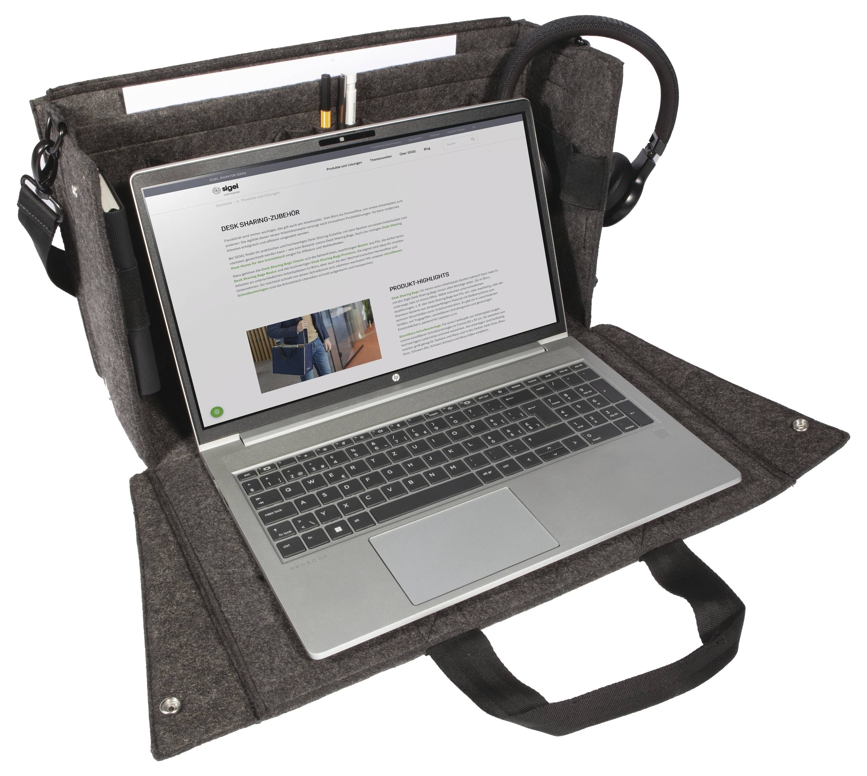 Laptop in einer Filztasche mit Schultergurten und Griffen geöffnet, auf dem Bildschirm wird eine Webseite angezeigt.