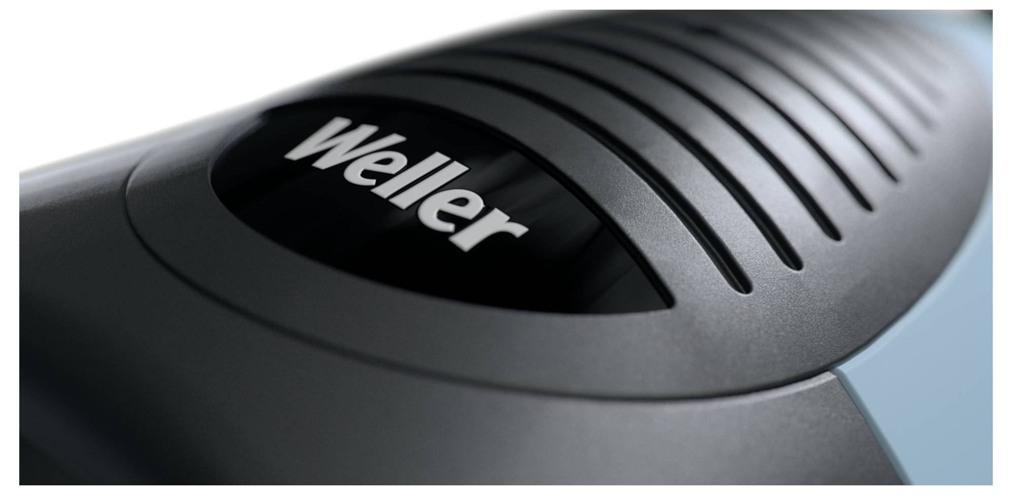 Nahaufnahme eines schwarzen tragbaren Werkzeugs oder Geräts der Marke Weller mit belüftetem Oberteil und gekrümmtem grauem Gehäuse.