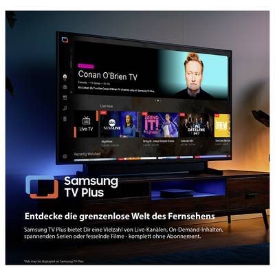 Werbeplakat für Samsung TV Plus: Smart-TV mit Streaming-Oberfläche und Kanal 'Conan O'Brien TV'; Text wirbt für Live-Kanäle, On-Demand-Inhalte und Filme ohne Abo.