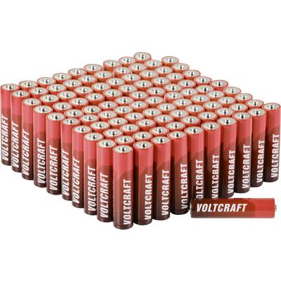 Ein großer Stapel roter Voltcraft-AA-Batterien in einer Pyramide angeordnet, mit einer Batterie, die horizontal davor liegt.
