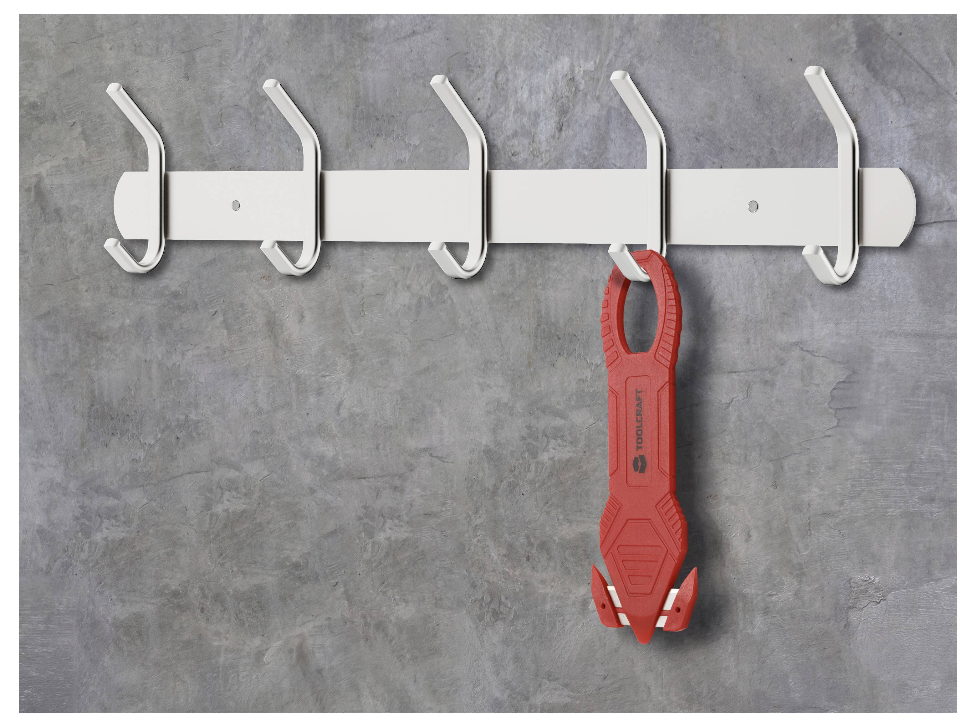Roter Feuerlöscher, der an einem weißen Wandhaken und einer Halterung an einer grauen Betonwand hängt.