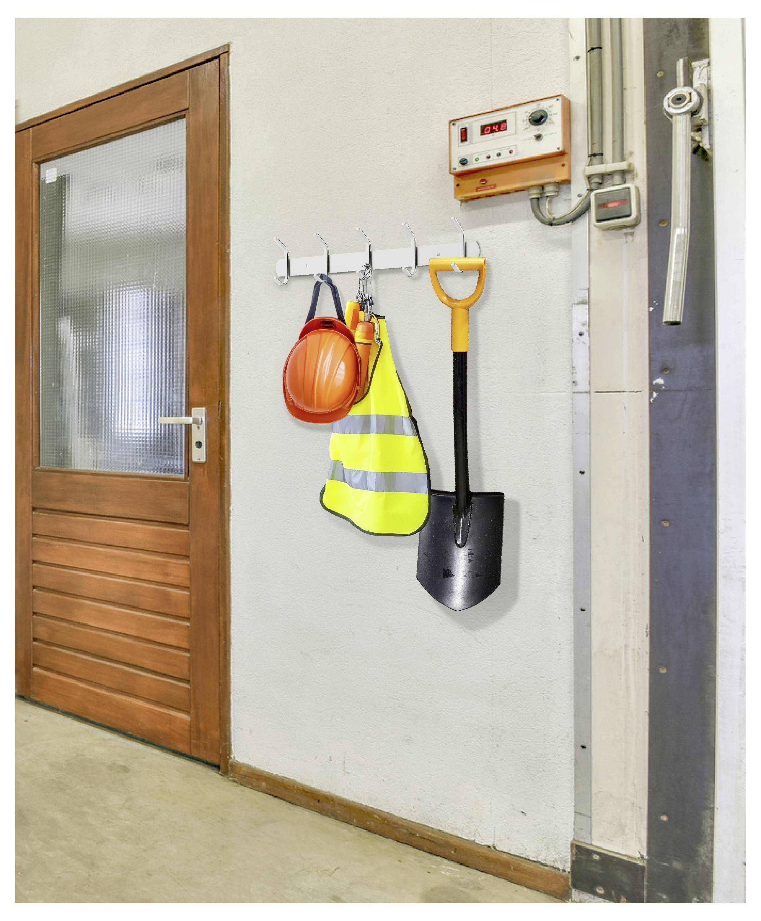 Arbeitsbereich-Wand mit hängender Sicherheitsausrüstung: Schutzhelm, Warnweste und Schaufel neben einer Holztür.