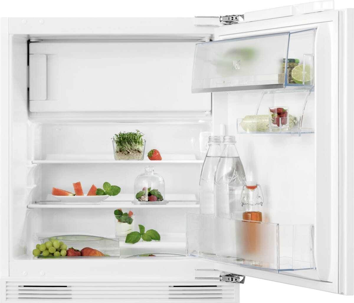 Kühlschrank öffnen mit spärlich gefüllten Regalen, die Wasserflaschen, Obst, Gemüse und kleine Behälter enthalten